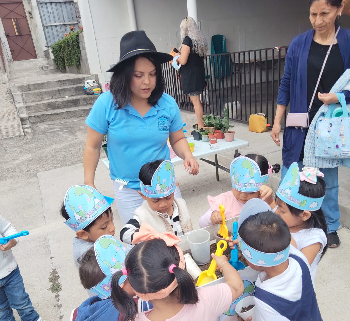 Teacher Licda Nely Rubin with children gathered around a table