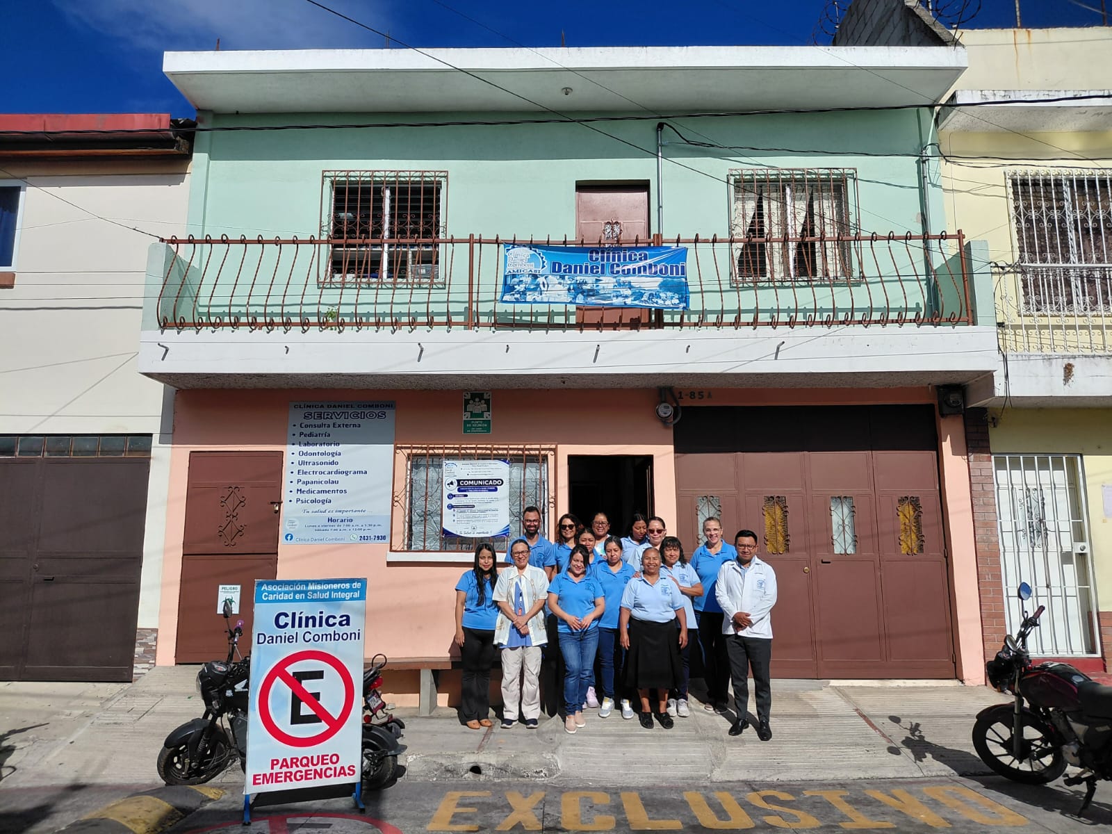 Staff and community members in front of the Clinica Daniel Comboni doctors office
